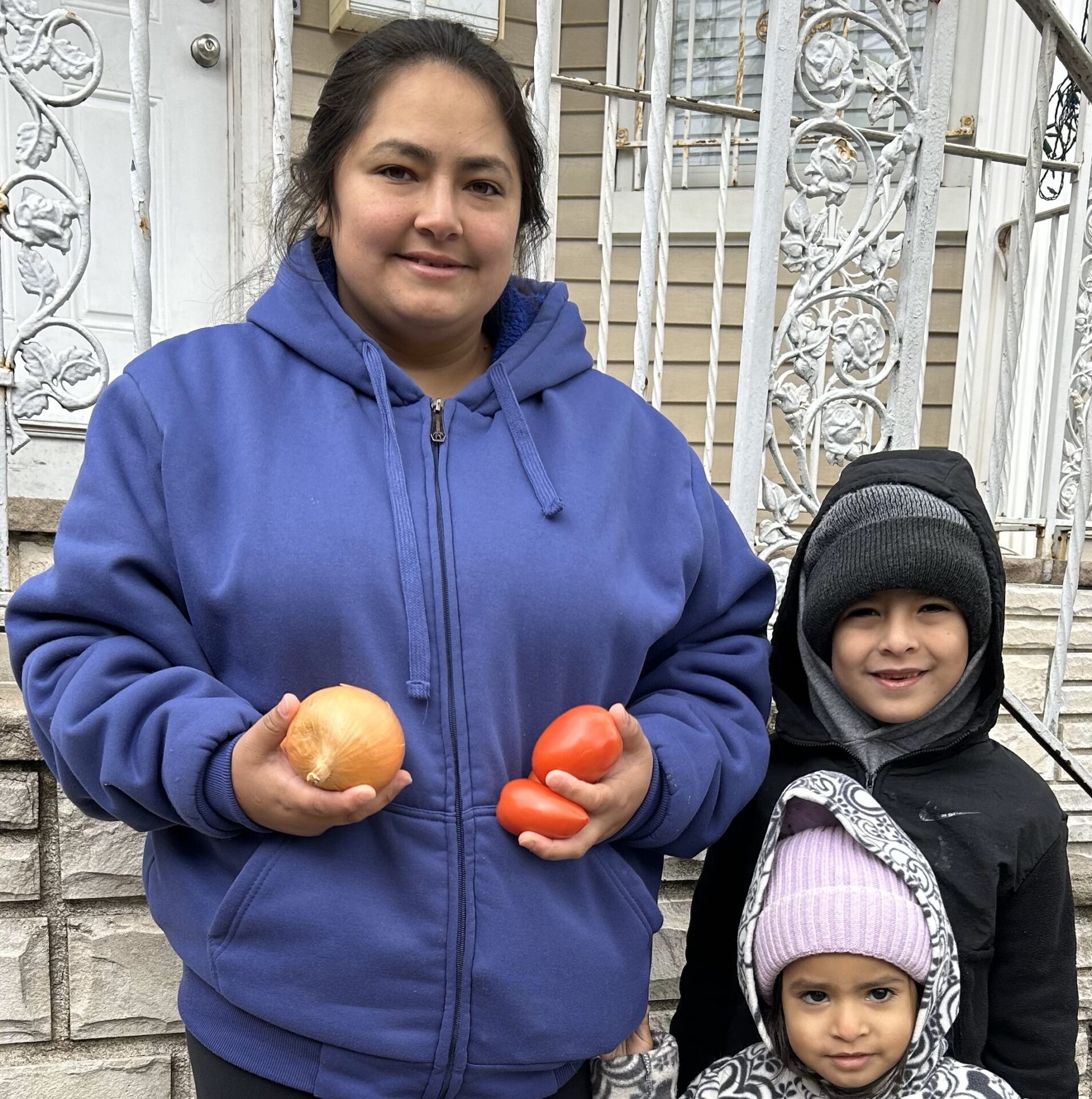 newly arrived from ecuador - mom + 2 kids 2 holding fresh tomatoes