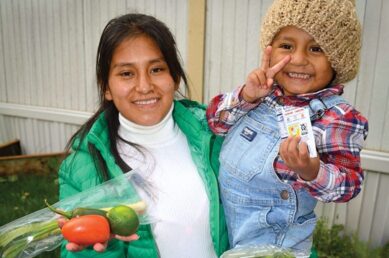 A mother and son receive fresh produce rescued from Table to Table.