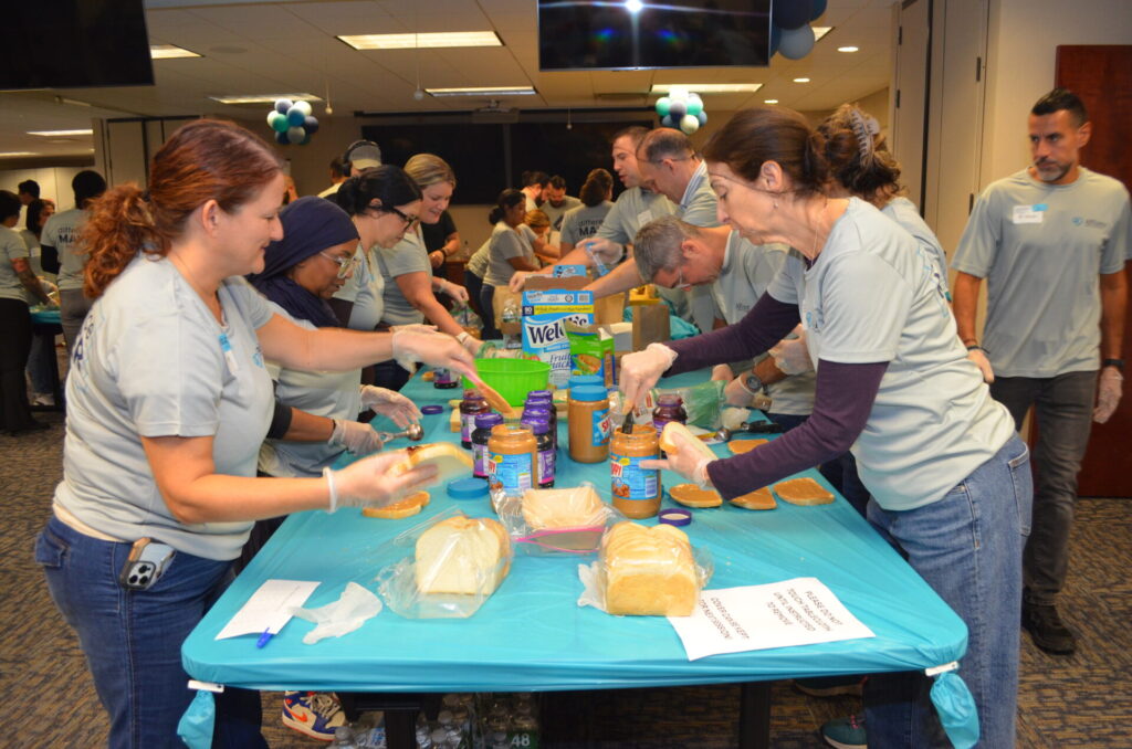 Employees from Affinity Federal Credit Union make peanut butter & jelly sandwiches for meal packs they made during a corporate volunteering event for Table to Table.